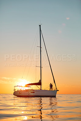 Buy stock photo Shot of a young couple going for an ocean cruise at sunset