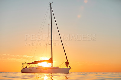 Buy stock photo Shot of a young couple going for an ocean cruise at sunset