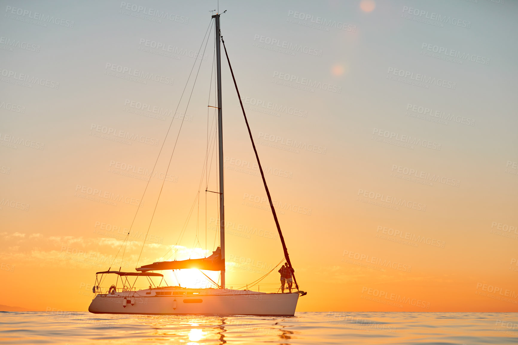 Buy stock photo Shot of a young couple going for an ocean cruise at sunset