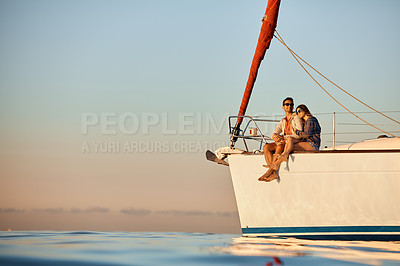Buy stock photo Shot of a young couple enjoying a cruise out on the ocean