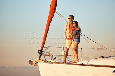 Buy stock photo Shot of a young couple enjoying a cruise out on the ocean