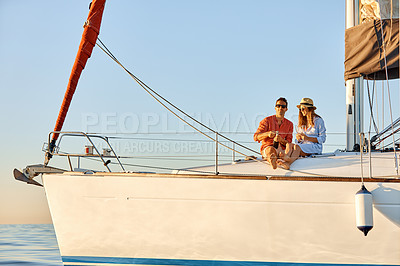 Buy stock photo Shot of a young couple drinking champagne together on an ocean cruise