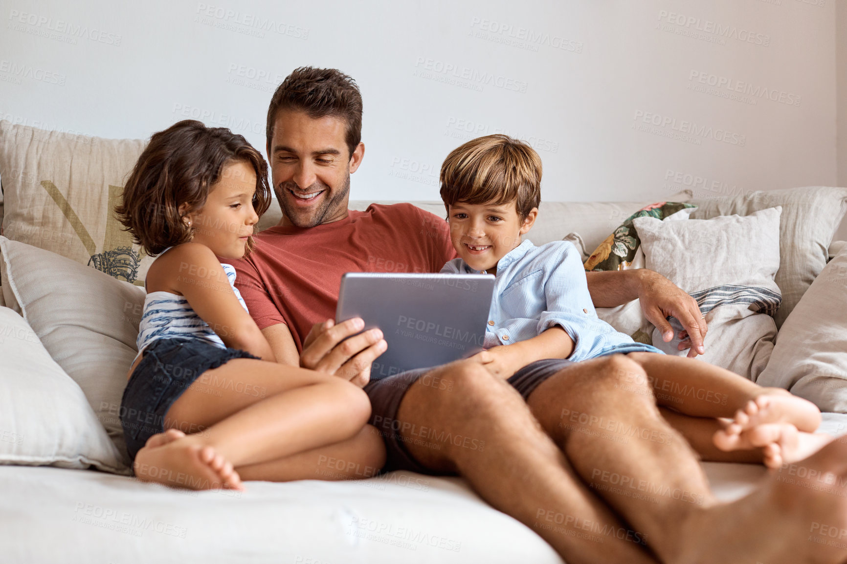 Buy stock photo Shot of a little girl and boy using a digital tablet while sitting with their father