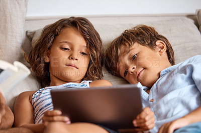 Buy stock photo Shot of a little girl and boy sharing a digital tablet at home