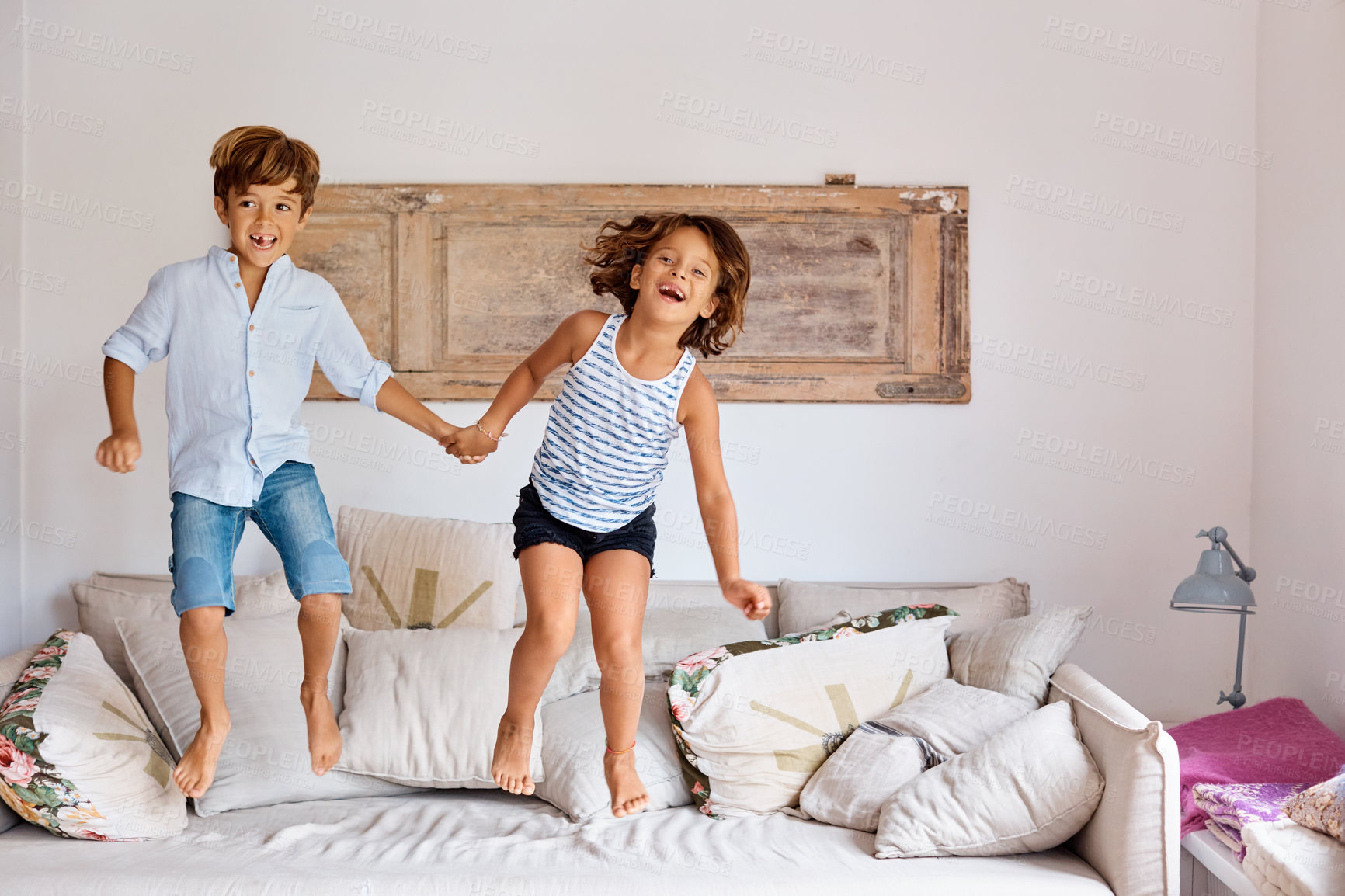 Buy stock photo Jumping, portrait and kids on couch with holding hands, fun moment or bonding on weekend break. Happy, siblings and children on sofa with energy, family relationship and playful connection in home.