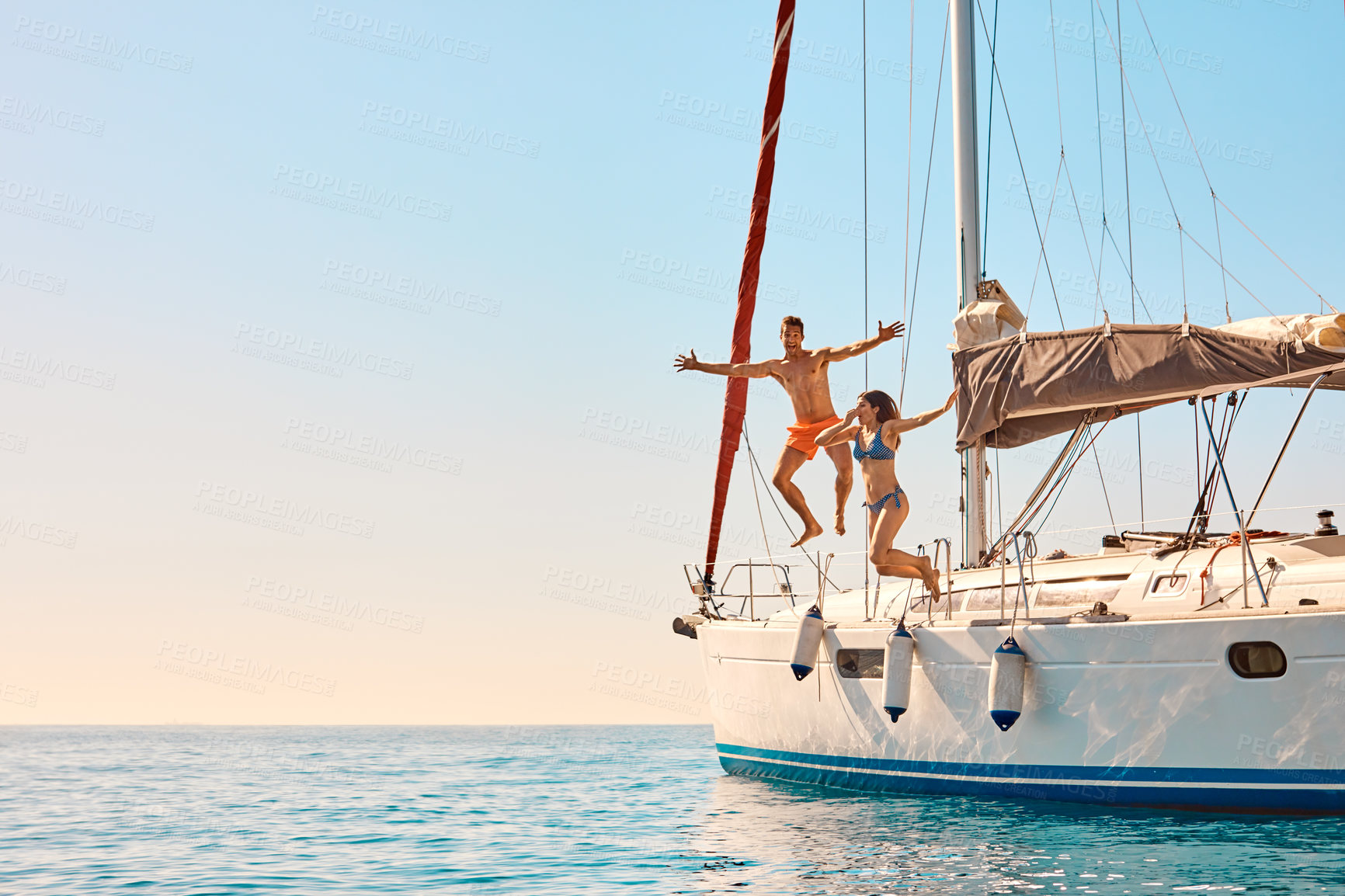 Buy stock photo Couple, boat and jump in water with energy, excited and relationship bonding on summer vacation. Happy man, woman and playful at yacht for swimming, plunge and honeymoon trip for holiday with space