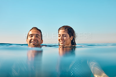 Buy stock photo Cropped shot of an affectionate young couple enjoying swim in the ocean
