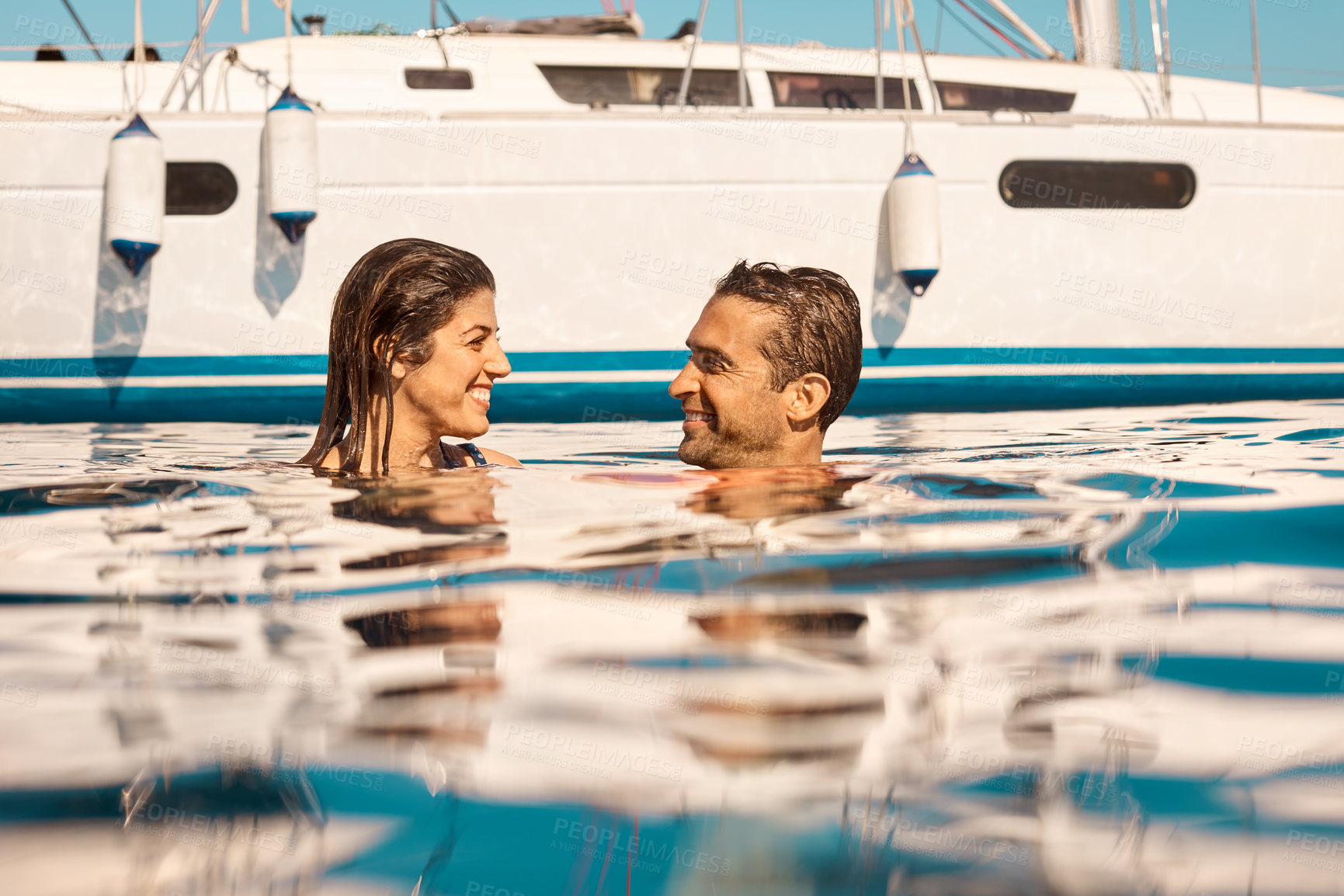 Buy stock photo Cropped shot of an affectionate young couple enjoying swim during a yacht cruise