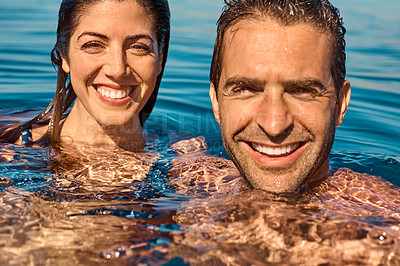 Buy stock photo Cropped portrait of an affectionate young couple enjoying swim in the ocean