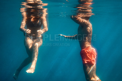 Buy stock photo Cropped shot of an unrecognizable young couple swimming in the ocean