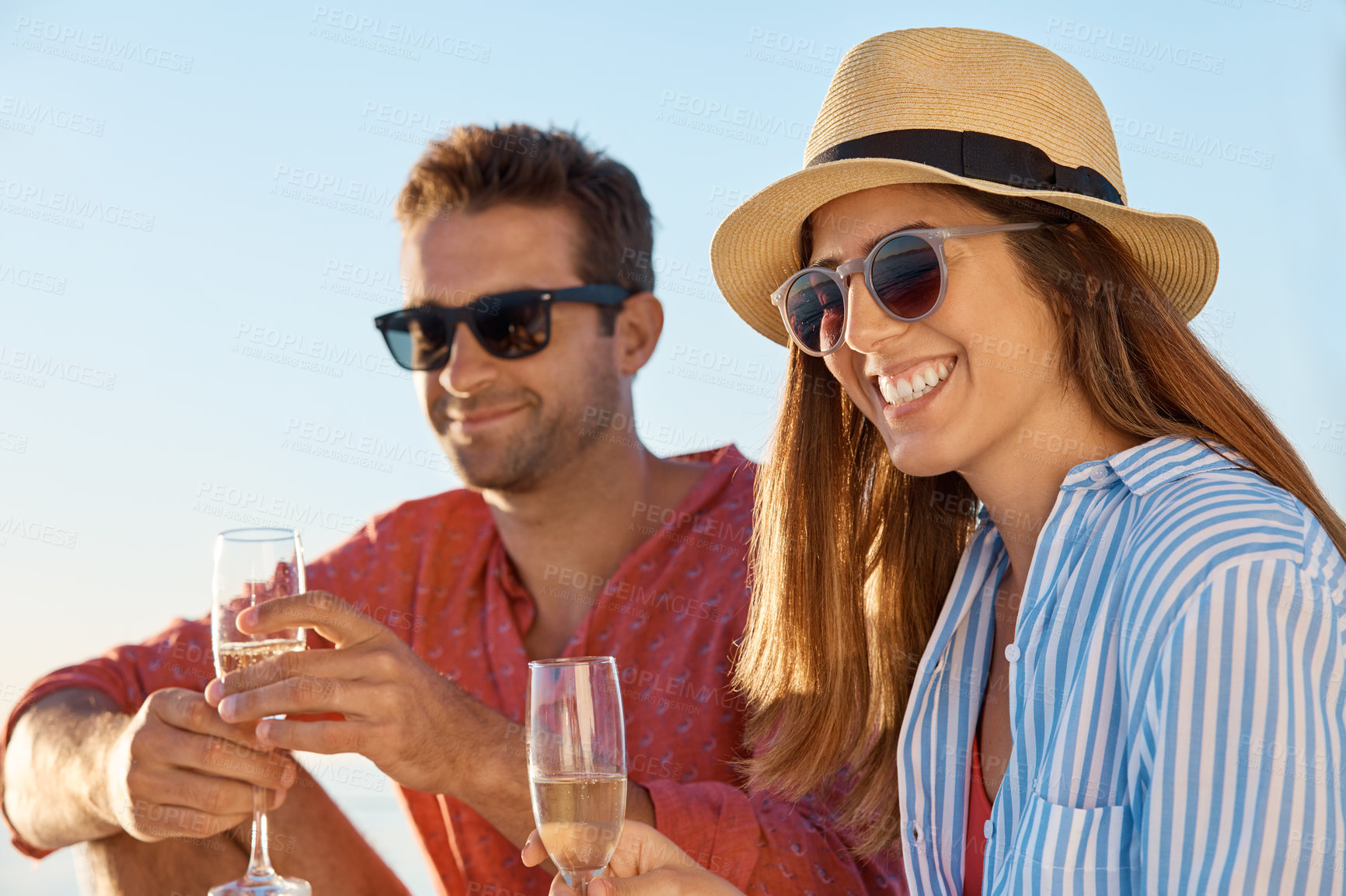 Buy stock photo Shot of a young couple drinking champagne together on an ocean cruise