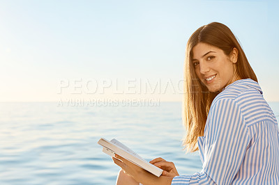 Buy stock photo Shot of a beautiful young woman reading a book an ocean cruise