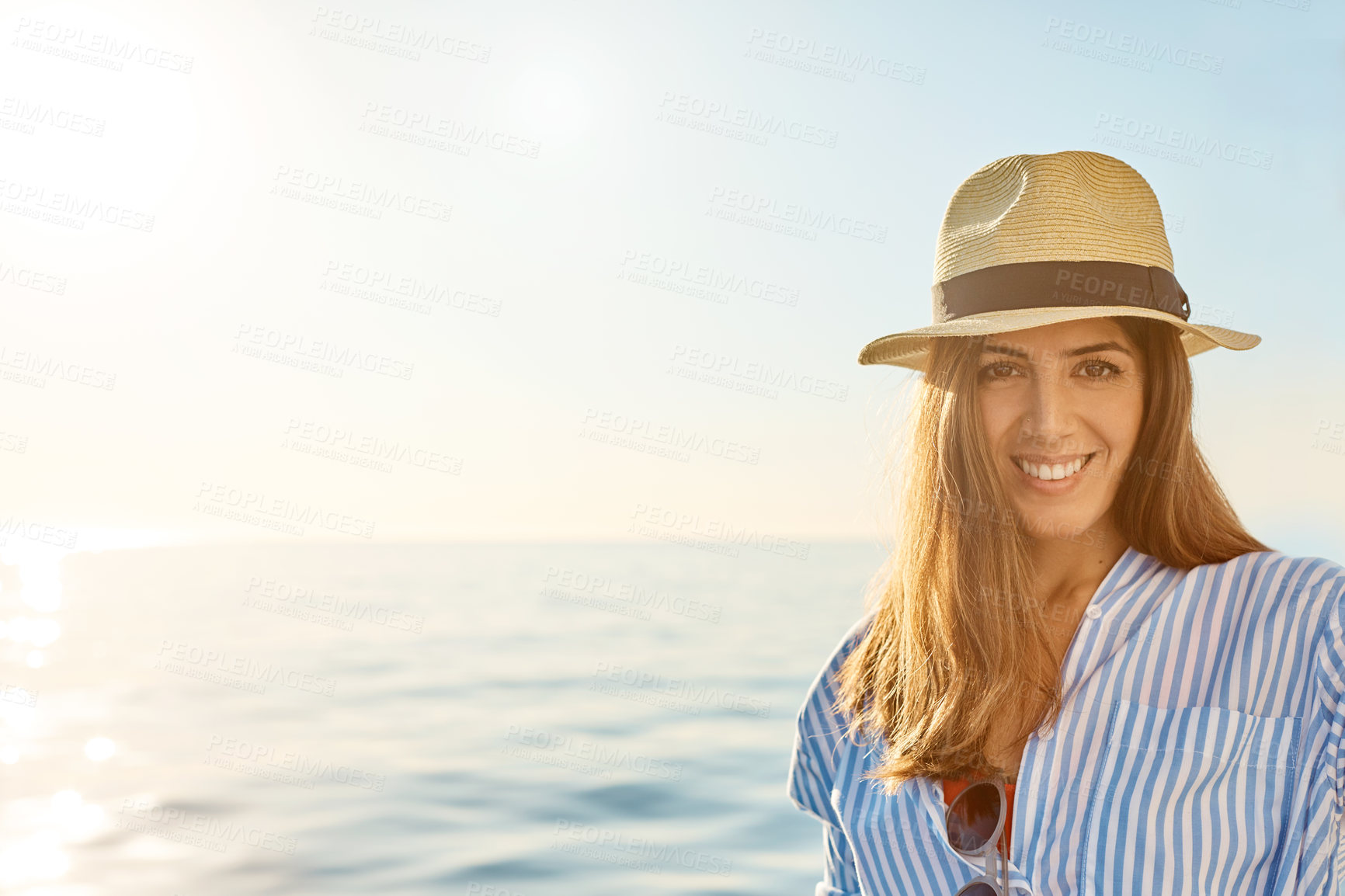 Buy stock photo Hat, portrait and space with happy woman at sea for holiday, travel or voyage in summer season. Confident, flare and smile with tourist person outdoor by ocean for getaway or vacation at sunset