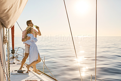 Buy stock photo Shot of a young couple drinking beer together on an ocean cruise