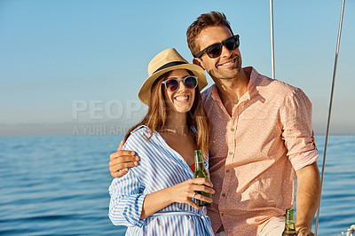 Buy stock photo Shot of a young couple drinking beer together on an ocean cruise
