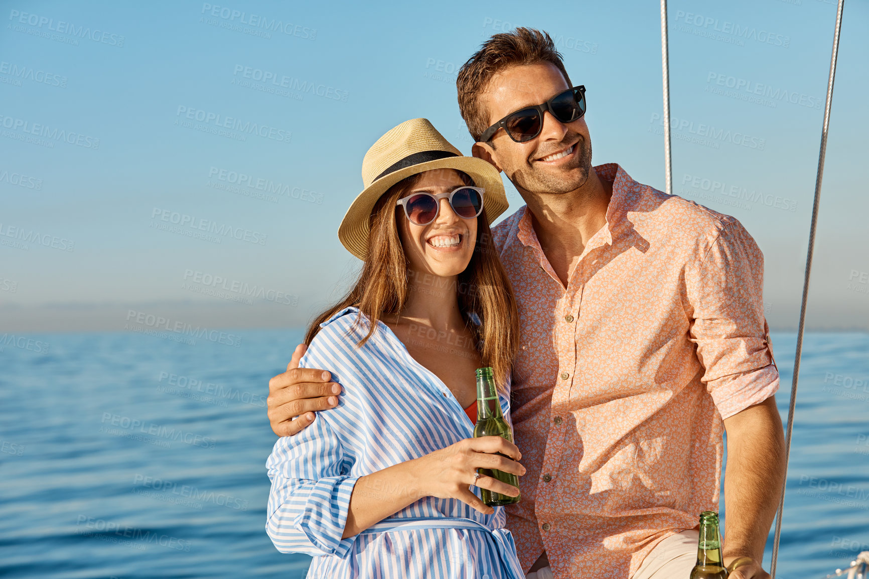 Buy stock photo Couple, hug and yacht on ocean with beer, sunglasses and love for bonding together on summer holiday. Happy, married people and embrace at sea with boat cruise, drink and travel vacation with shades.