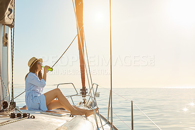 Buy stock photo Shot of a beautiful young woman enjoying a drink on an ocean cruise