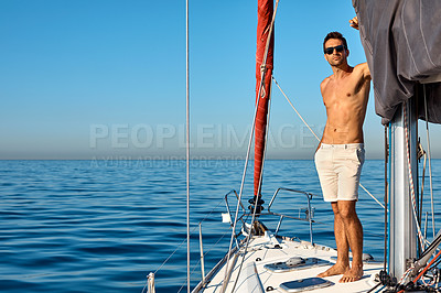 Buy stock photo Shot of a handsome young man going for an ocean cruise on a boat
