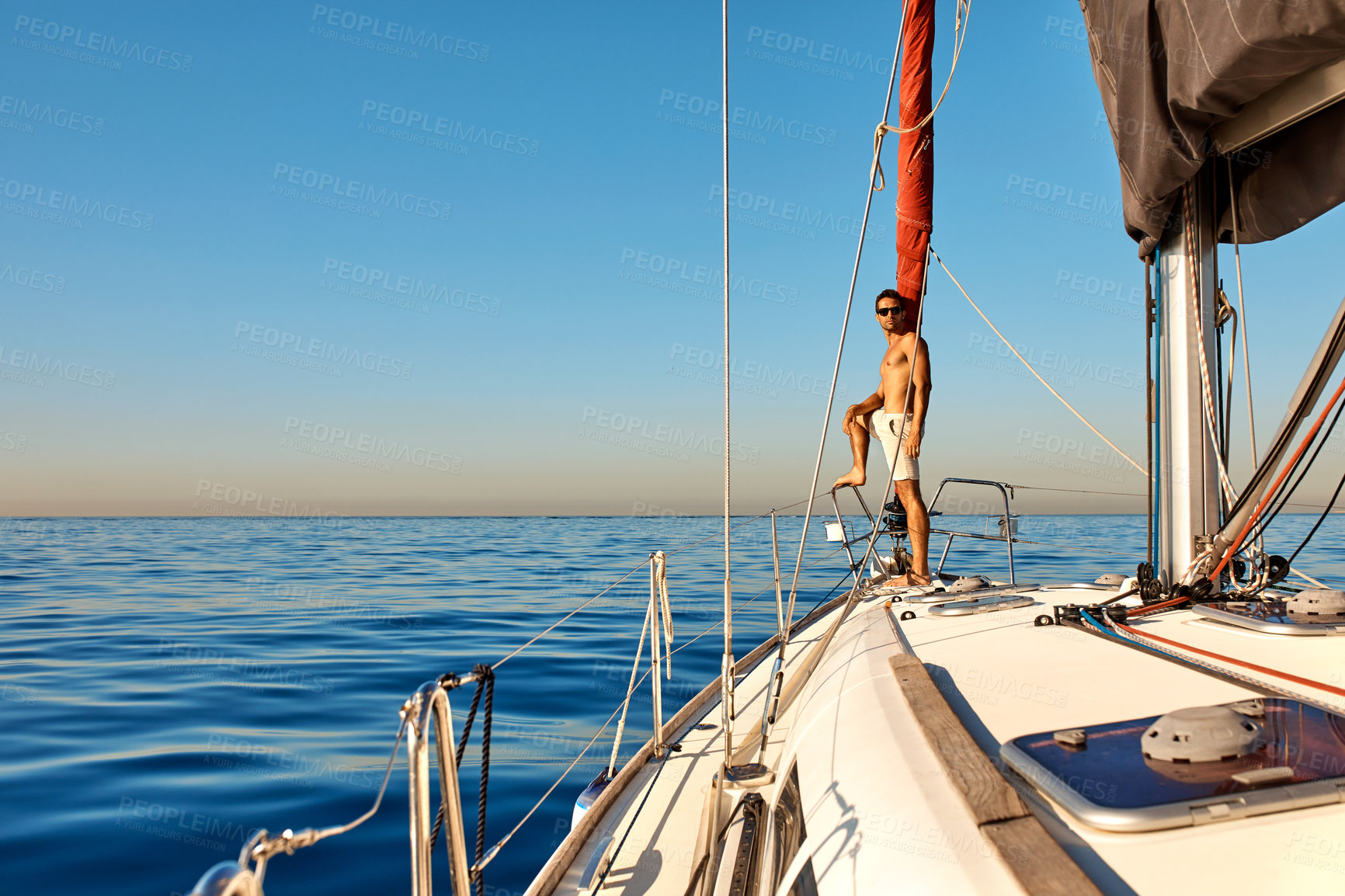 Buy stock photo Shot of a handsome young man going for an ocean cruise on a boat