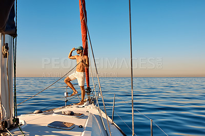 Buy stock photo Shot of a handsome young man going for an ocean cruise on a boat