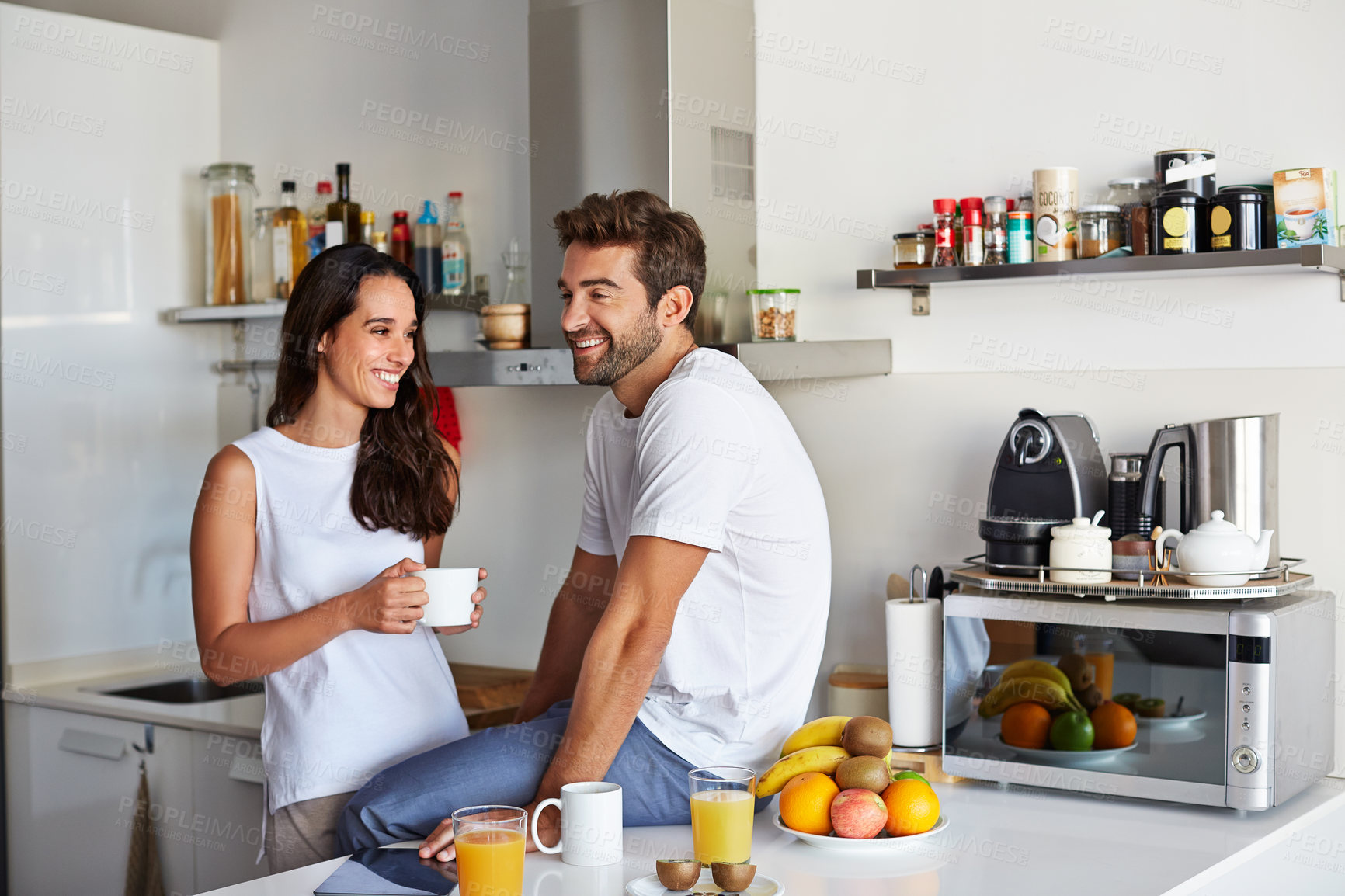 Buy stock photo Happy couple, relax and conversation with smile in kitchen for commitment, bonding and partner. People, together and communication for anniversary, romance and support with spouse and love in home