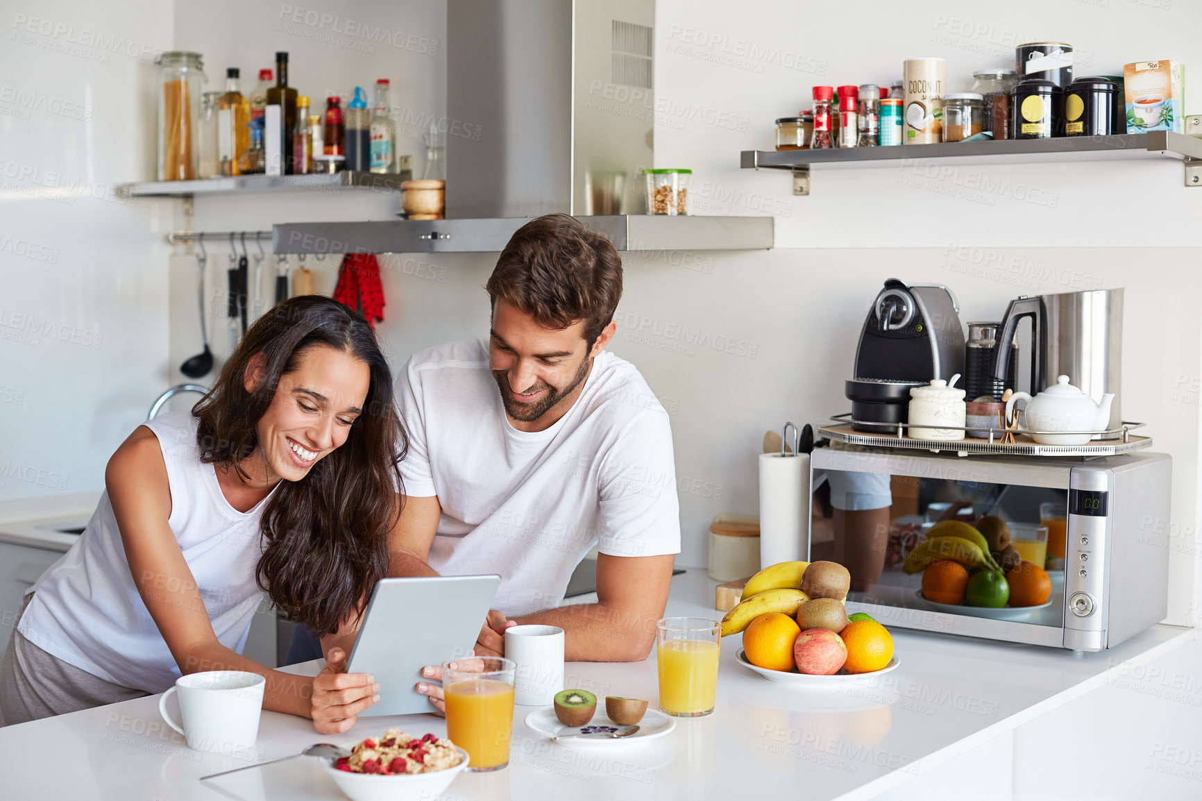 Buy stock photo Breakfast, research and tablet with happy couple in kitchen of home together for start of morning. App, food and recipe planning with people at counter in apartment for health, nutrition or wellness