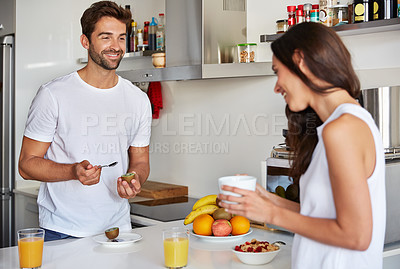 Buy stock photo Shot of a young couple having a relaxing breakfast together at home