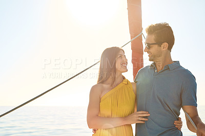 Buy stock photo Shot of a young couple enjoying a cruise out on the ocean