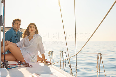 Buy stock photo Shot of a young couple enjoying a cruise out on the ocean