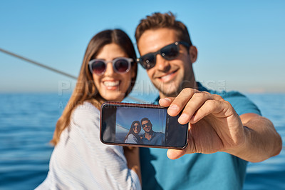 Buy stock photo Shot of a young couple taking a selfie together on an ocean cruise