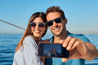 Buy stock photo Shot of a young couple taking a selfie together on an ocean cruise