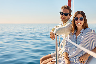 Buy stock photo Shot of a young couple enjoying a cruise out on the ocean