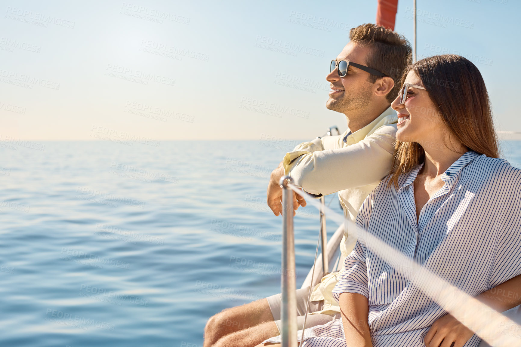 Buy stock photo Shot of a young couple enjoying a cruise out on the ocean