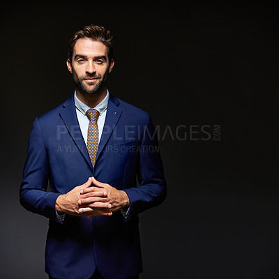 Buy stock photo Studio portrait of a handsome young businessman posing against a dark background