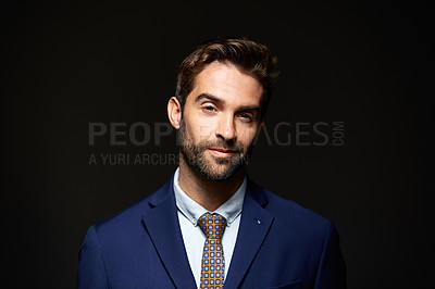 Buy stock photo Studio portrait of a handsome young businessman posing against a dark background