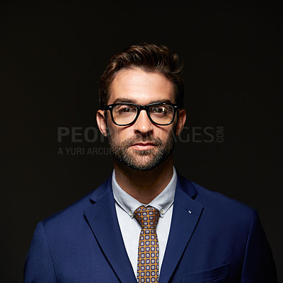 Buy stock photo Studio portrait of a handsome young businessman posing against a dark background