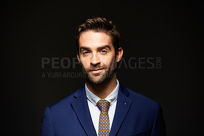 Buy stock photo Studio portrait of a handsome young businessman posing against a dark background