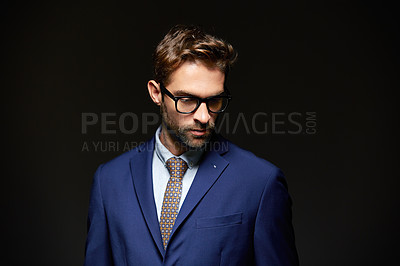 Buy stock photo Studio shot of a handsome young businessman posing against a dark background