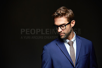 Buy stock photo Studio shot of a handsome young businessman posing against a dark background