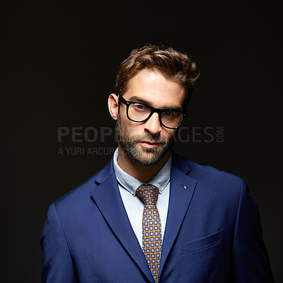 Buy stock photo Studio portrait of a handsome young businessman posing against a dark background