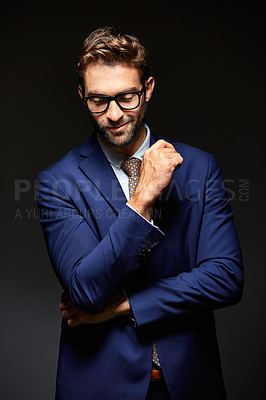 Buy stock photo Studio shot of a handsome young businessman posing against a dark background