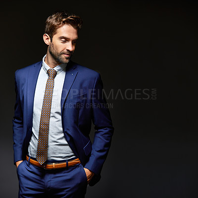 Buy stock photo Studio shot of a handsome young businessman posing against a dark background