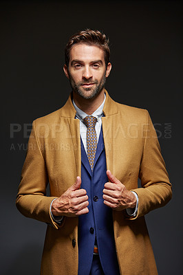 Buy stock photo Studio portrait of a handsome young businessman posing against a dark background