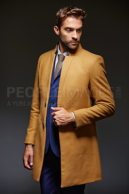 Buy stock photo Studio shot of a handsome young businessman posing against a dark background