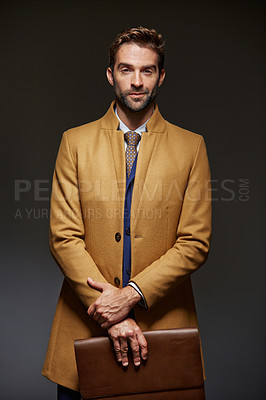 Buy stock photo Studio portrait of a handsome young businessman posing against a dark background