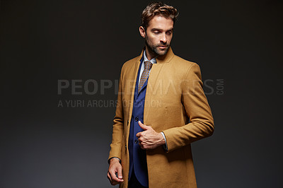 Buy stock photo Studio shot of a handsome young businessman posing against a dark background