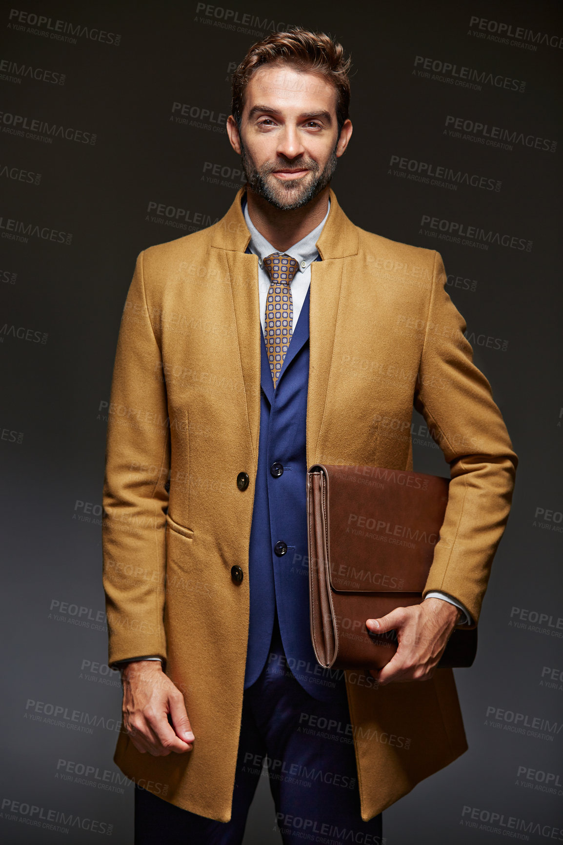 Buy stock photo Studio portrait of a handsome young businessman posing against a dark background