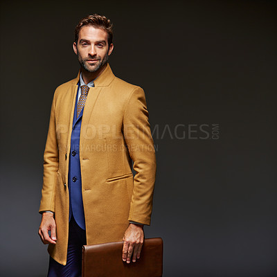 Buy stock photo Studio portrait of a handsome young businessman posing against a dark background