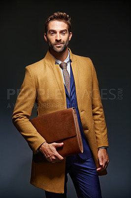Buy stock photo Studio portrait of a handsome young businessman posing against a dark background