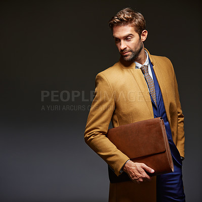 Buy stock photo Studio shot of a handsome young businessman posing against a dark background